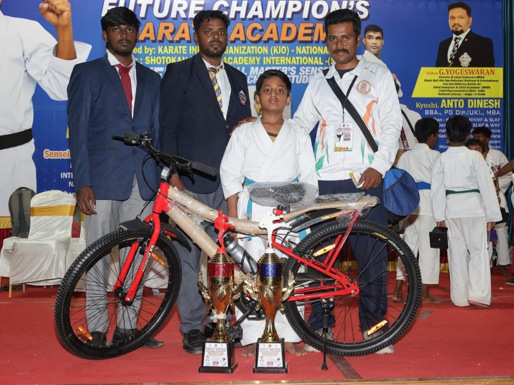 Student receiving bicycle and trophies at award ceremony